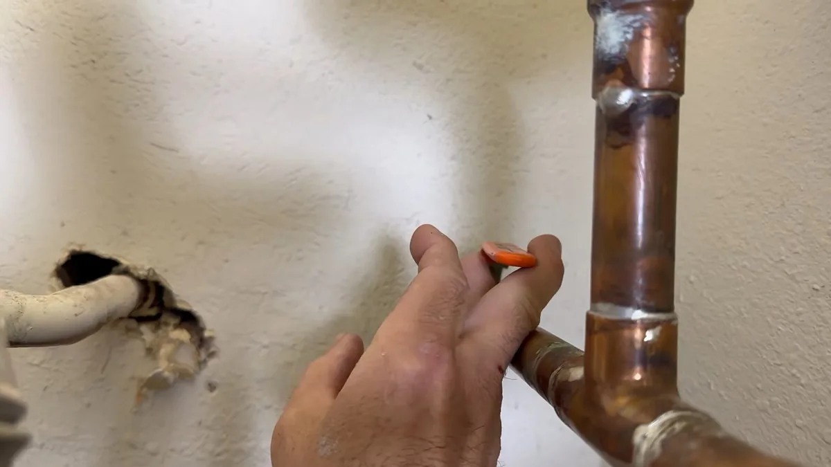 Copper pipe leak point beside a damaged wall opening for Leak Detection in Fountain Valley, CA in Fountain Valley
