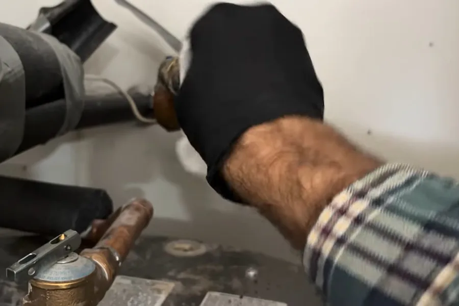 Water heater inlet hose and shutoff connection being repaired for Water Heater Installation in Fountain Valley, CA in Fountain Valley